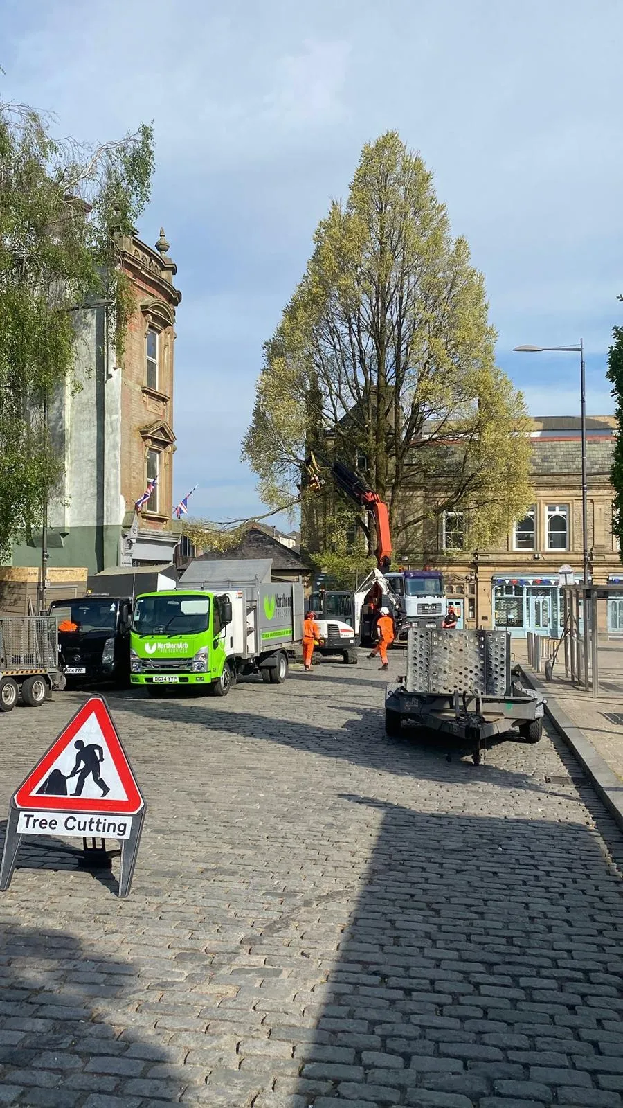 Truck-mounted grab crane dismantling a tree in Darwen town centre