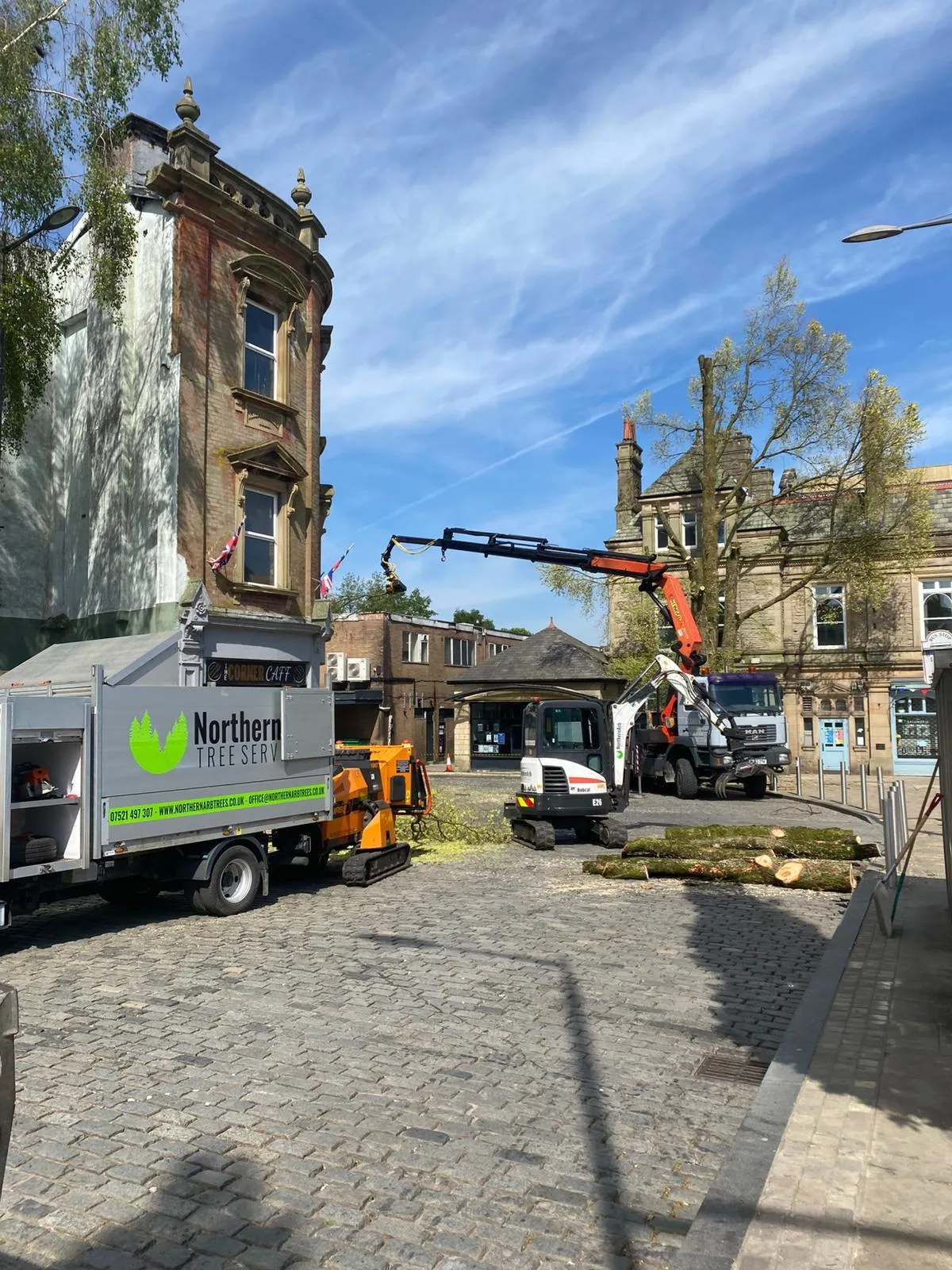 Tractor and grapple loading felled timber in the pedestrian square