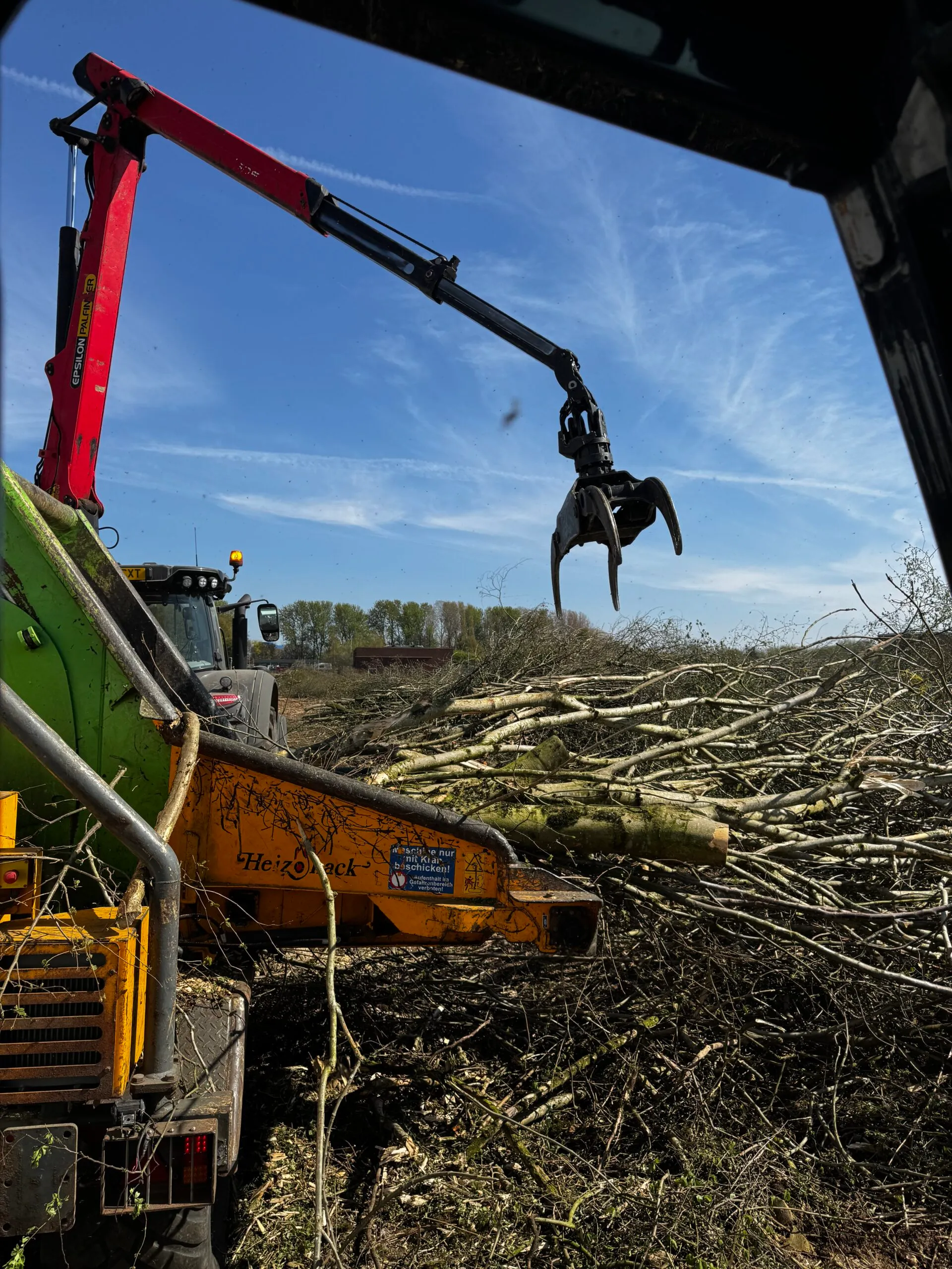 NorthernArb grapple loading cleared brash onto a chip truck