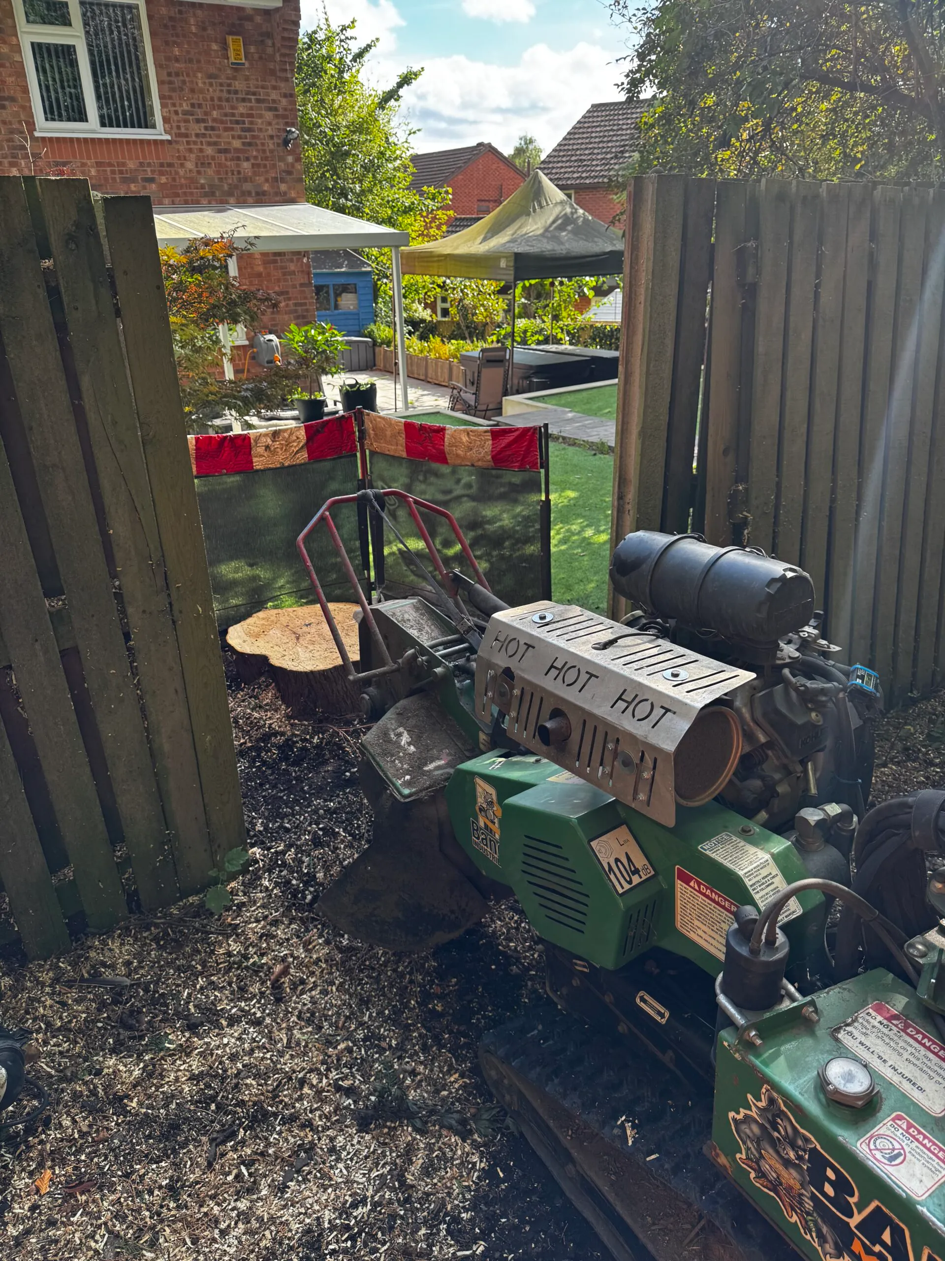 Stump grinder machine clearing a tree stump in a residential garden